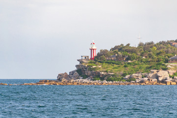 Bright red and white lighthouse on a cliff