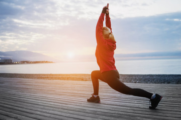Running stretching before running. Athlete on the seacoast.