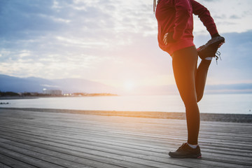 Running stretching before running. Athlete on the seacoast.