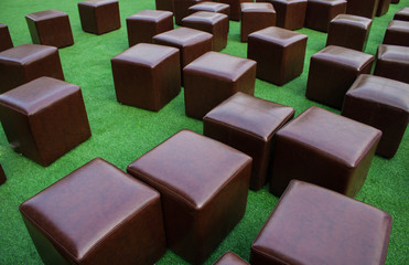 Fototapeta premium Brown Cube chair On the grass background