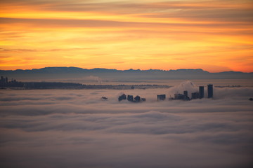 Vancouver sunrise in the fog.  Tall buildings pushing up through low lying fog.