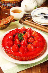 Freshly baked hot strawberry pie served on a white plate with tea       