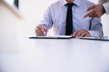 Sales manager giving advice application form document, considering mortgage loan offer for car and house insurance.