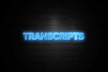 Transcripts neon Sign on brickwall