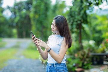 Asian girl  talking on the phone in the garden