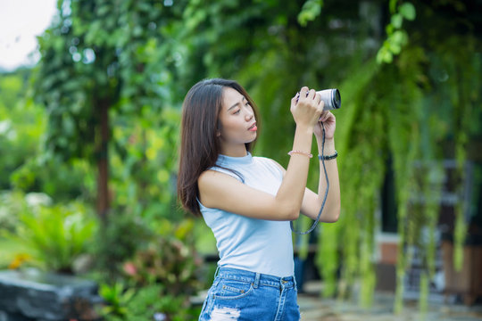 Young asian girl taking  photo in the garden