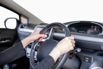 Hand holding steering wheel in modern private car with blank windshield