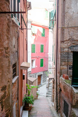 Fototapeta na wymiar Old beautiful empty narrow streets with outdoor cafe in coastal village in Cinque Terre, Italy
