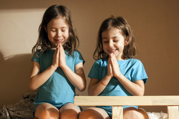Little girls pray before going to bed in bed