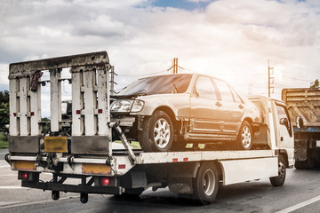 Broken car on tow truck after traffic accident, on the road service
