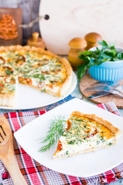 Slice of homemade french quiche pie with tomato, cheese and herb on a plate