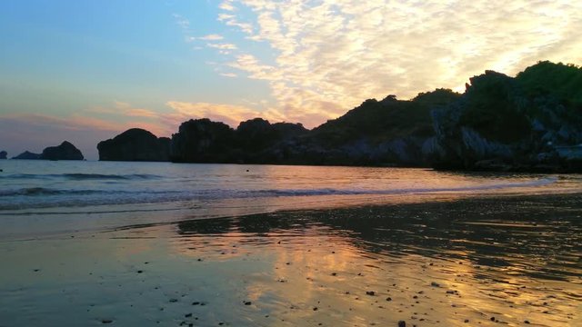 Mom and kid playing on a beach UHD Handheld pan view of a beach outside Cat ba city, in the halong bay on a sunny december evening dusk sunset