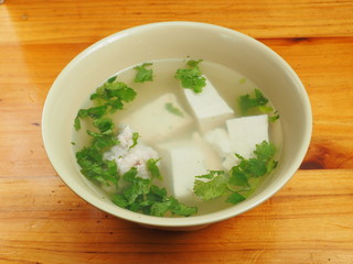 A bowl of tofu soup on the table