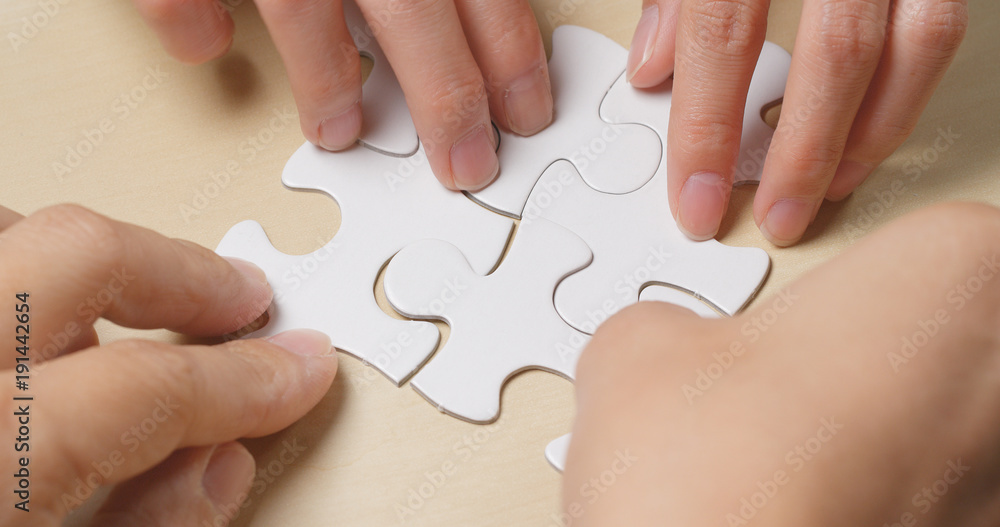 Wall mural Hand put the piece of jigsaw puzzle, teamwork concept