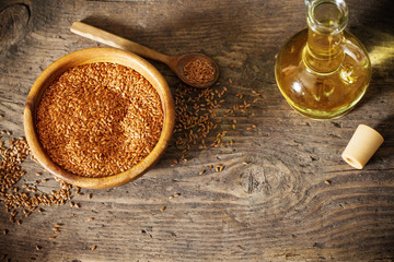 flax seeds and linseed oil in a glass jug on a wooden table