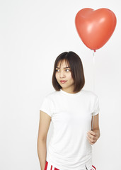 Woman holding big red balloon heart