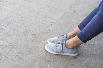 Blue sneakers on asian female feet., with copy space for text. fashion concept. waiting concept.