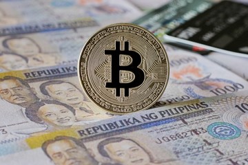 Silver Bitcoin on Philippine Peso Banknotes Background