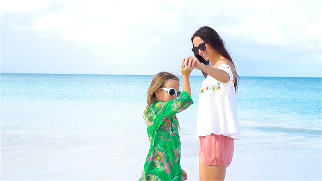 Little girl and young mother on the beach hava lot of fun together