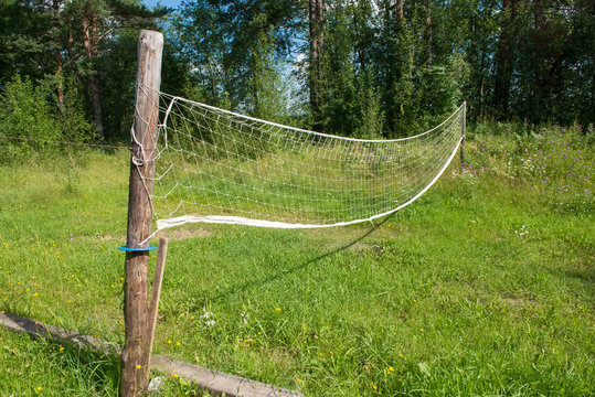Village volleyball field with overgrown grass and sagging grid