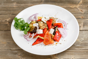 Grilled vegetables salad with red bell pepper, eggplant, onions, feta cheese, peppers, cilantro and tomato.