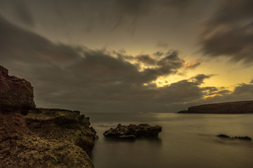 Obraz premium Beach with big lava stones at sunset. Canary Islands and long exposure