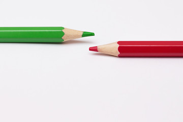 two pencils of green and red, symbolize the opposite