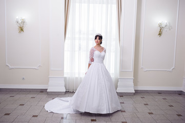 Fototapeta na wymiar Beautiful bride in a wedding dress white interior