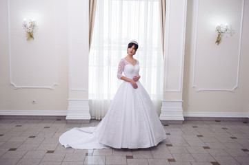 Beautiful bride in a wedding dress white interior