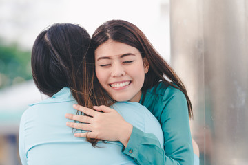 Portrait of happy asian women hugging each friend outdoor city background