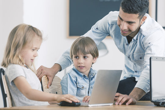 Girl and boy using laptop