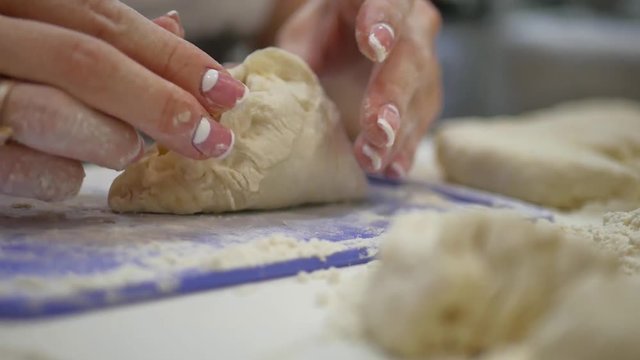 Home food. Making dough by female hands on kitchen table. Hands kneading dough on white table