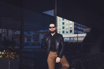 young beard man posing in the street, fashion style, sunglasses, mustache