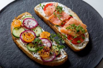Healthy and tasty toast bread with tomato, radish, salmon fish and cheese on it.