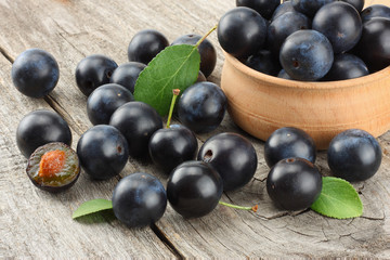blackthorn berries with green leaf on old wooden table