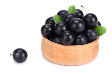 blackthorn berries in wooden bowl with green leaf isolated on white background