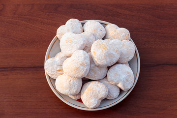 Plate with heart shaped cookies covered with powdered sugar