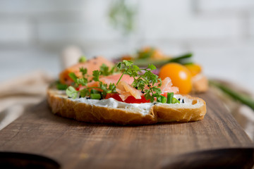 Healthy and tasty toast bread with tomato, radish, salmon fish and cheese on it.