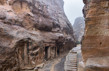 Tombs and stone stairs at heavy rain in Little Petra - ancient Nabatean city. Jordan