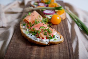 Healthy and tasty toast bread with tomato, radish, salmon fish and cheese on it.