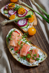 Healthy and tasty toast bread with tomato, radish, salmon fish and cheese on it.