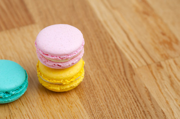 Colorful pastel macaroons on wooden table. French almond cookies. Place for text
