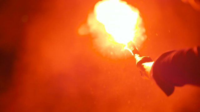 Close-up of a burning signal flare held by a man
