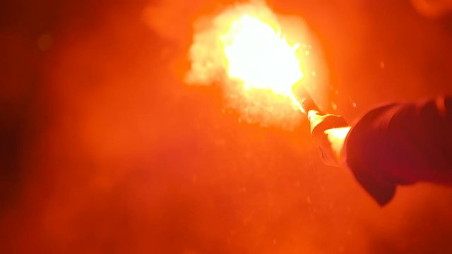 Close-up of a burning signal flare held by a man
