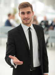 confident young businessman holds out his hand for greeting
