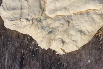 Raw fresh yeast dough for baking on rustic wooden table