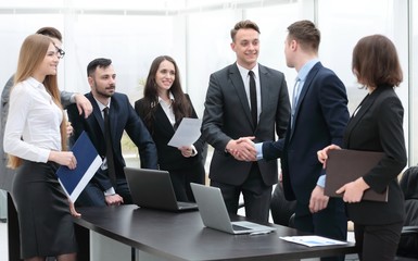 handshake business partners at a meeting in the office