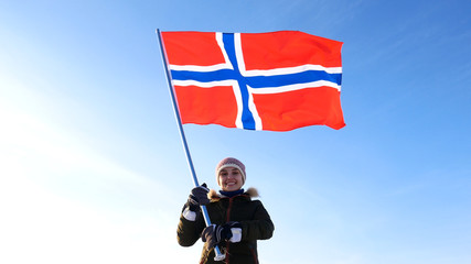 Woman with norway flag on the top point. Succesful winer consept