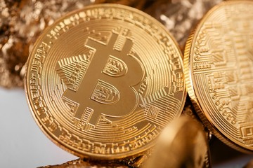Closeup of golden bitcoin as main cryptocurrency with gold lumps being blurred on background. Blockchain digital electronic virtual money finance banking futuristic trend innovation