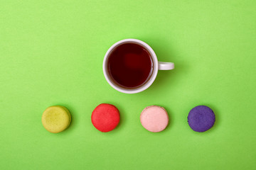Colorful sweet macaroons and a cup of tea. Delicious breakfast. Top view.